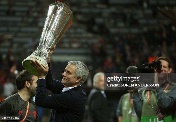 Manchester United's Portuguese manager Jose Mourinho celebrates with the trophy after his team won the UEFA Europa League final football match Ajax...