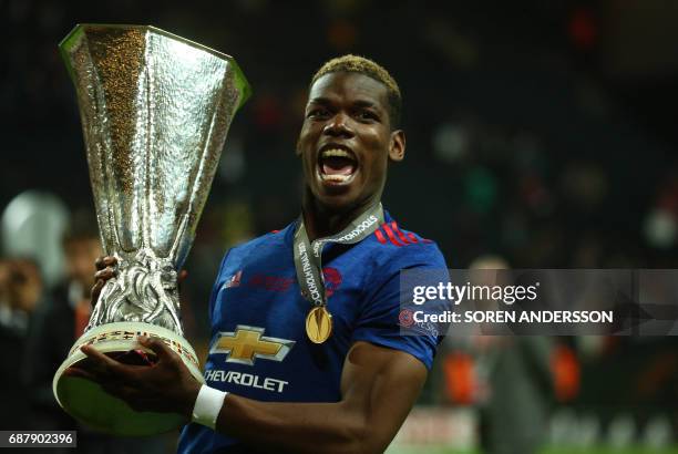 Manchester United's French midfielder Paul Pogba celebrates with the trophy after his team won the UEFA Europa League final football match Ajax...