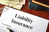 Liability insurance on a wooden table with glasses.