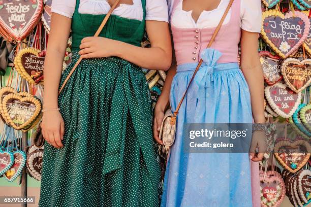 oktoberfest dirndl vor lebkuchenherzen - dirndl stock-fotos und bilder