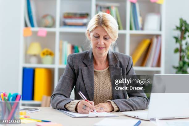 intelligente frau im büro, signieren von relevanten dokumenten - steuerberater stock-fotos und bilder