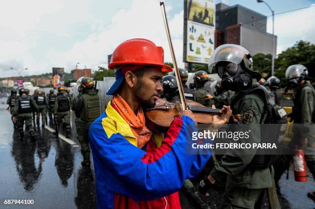 An opposition demonstrator plays the violin during a protest against President Nicolas Maduro in Caracas, on May 24, 2017. Venezuela's President...