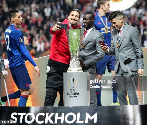 Zlatan Ibrahimovic of Manchester United takes a photo near the trophy as he celebrates after the UEFA Europa League Final match between Ajax and...