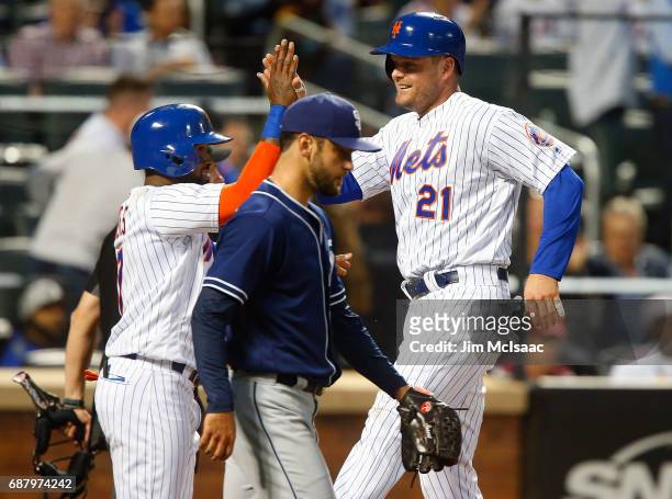 Lucas Duda and Jose Reyes of the New York Mets celebrate after both scored in the third inning against Jarred Cosart of the San Diego Padres after a...