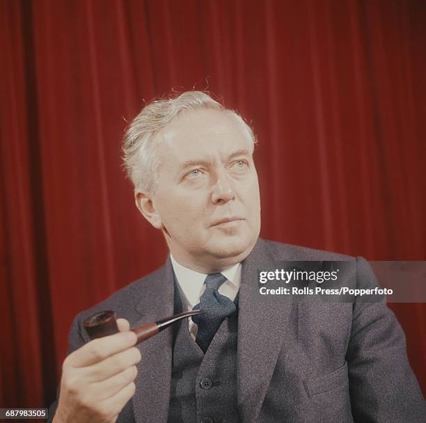 Portrait of English Labour Party politician and Prime Minister of the United Kingdom, Harold Wilson posed holding a pipe circa 1965.