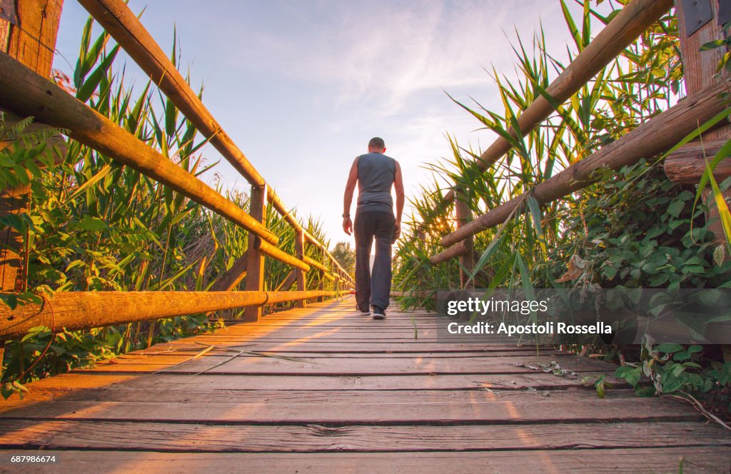 Man walking on the wooden bridge