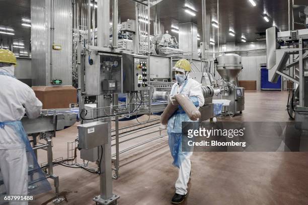 An employee carries imported Smithfield Foods Inc. Pork meat on a production like that processes the pork into ham at the WH Group Ltd. Facility in...