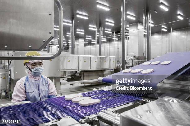 An employee monitors ham, produced from imported Smithfield Foods Inc. Pork meat, moving along a conveyor belt on a production line at the WH Group...