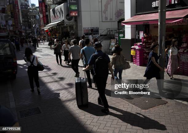 Pedestrians walk through a street in the Shibuya area of Tokyo, Japan, on Tuesday, May 23, 2017. Japan's consumer price index for April will be...