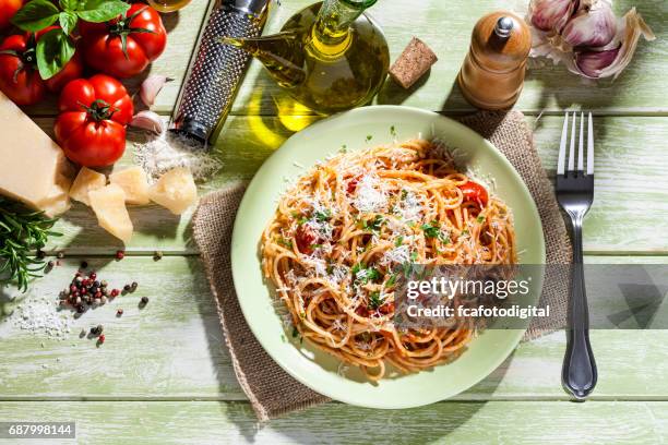 pasta plate and ingredients on green kitchen table - parmesan cheese overhead stock pictures, royalty-free photos & images