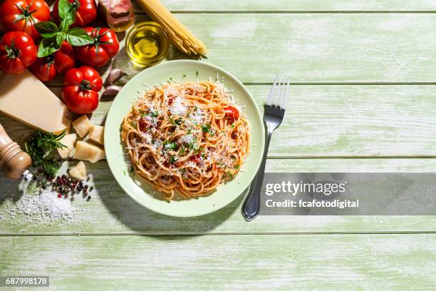 pasta tallrik och ingredienser på gröna köksbord - italian culture bildbanksfoton och bilder