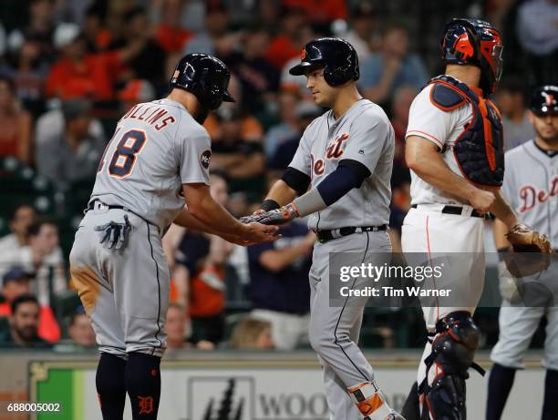 Tyler Collins of the Detroit Tigers congratulates Jose Iglesias after a ninth-inning home run against the Houston Astros at Minute Maid Park on May...