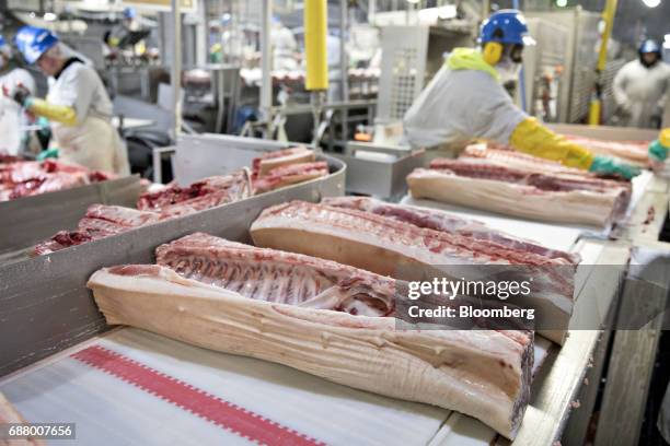 Sections of pork move along a conveyor at a Smithfield Foods Inc. Pork processing facility in Milan, Missouri, U.S., on Wednesday, April 12, 2017. WH...