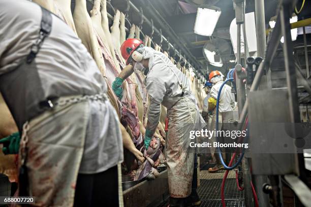 Employees remove internal organs from pigs at a Smithfield Foods Inc. Pork processing facility in Milan, Missouri, U.S., on Wednesday, April 12,...