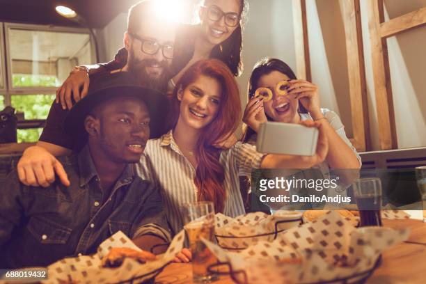 groep vrienden nemen van een selfie in een bar - sun flare on glass stockfoto's en -beelden