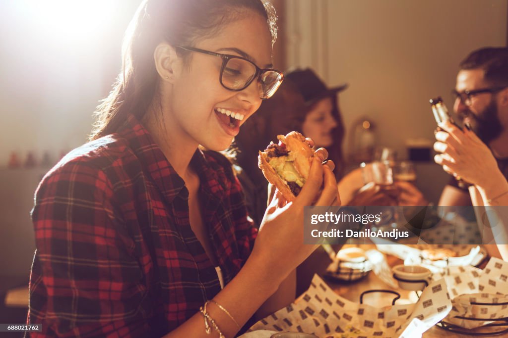 Beautiful young woman enjoying her burger
