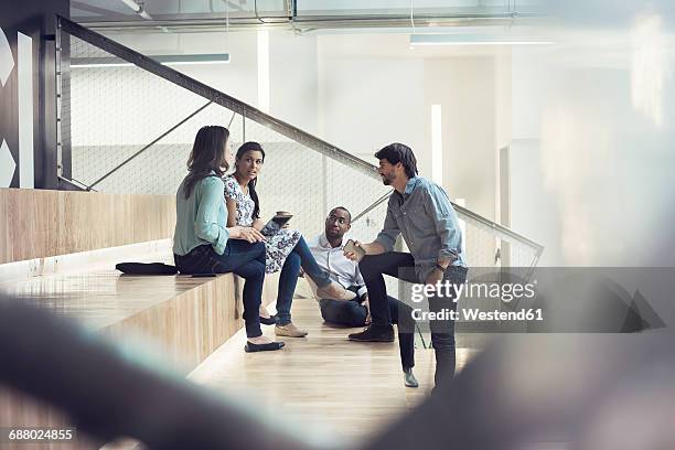 young business people discussing, sitting on stairs - successful asian team stock-fotos und bilder
