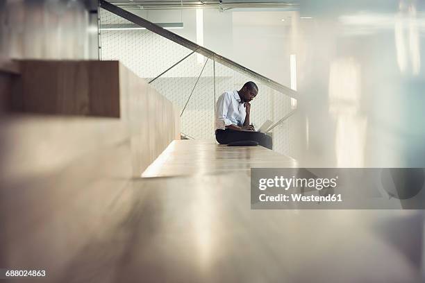 businessman sitting on stairs using laptop - funky office stock pictures, royalty-free photos & images