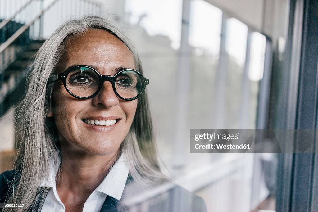 Smiling businesswoman looking out of window