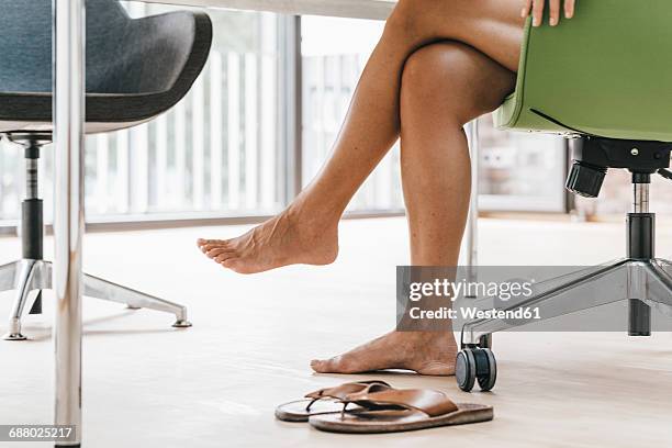woman sitting in office with bare feet - barefoot stock pictures, royalty-free photos & images