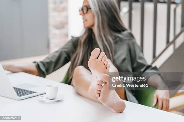 woman working in office with bare feet on desk - womans bare feet fotografías e imágenes de stock