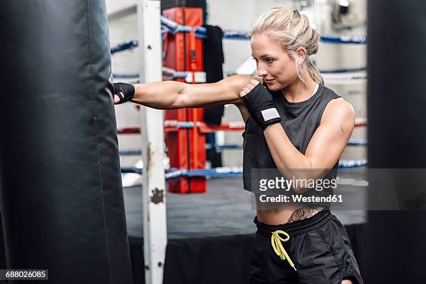 female boxer exercising at punch bag - punching bag stock pictures, royalty-free photos & images
