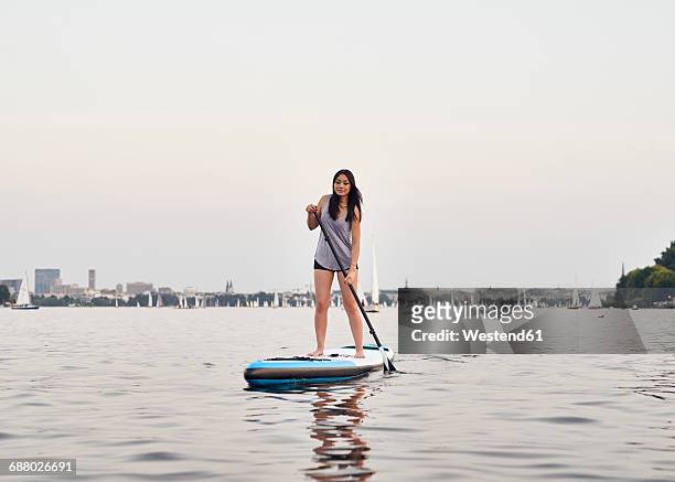 germany, hamburg, young woman on paddleboard enjoying summer - alster lake stock pictures, royalty-free photos & images