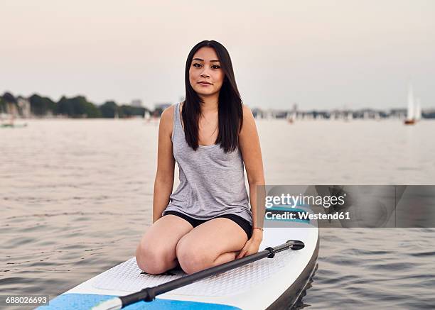 germany, hamburg, young woman on paddleboard enjoying summer - alster lake stock pictures, royalty-free photos & images