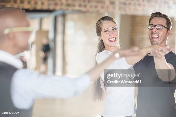 smiling dance partners together in dance class with instructor - danse de salon photos et images de collection