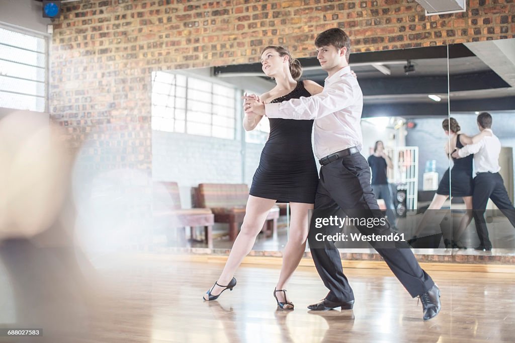 Couple dancing salsa in studio