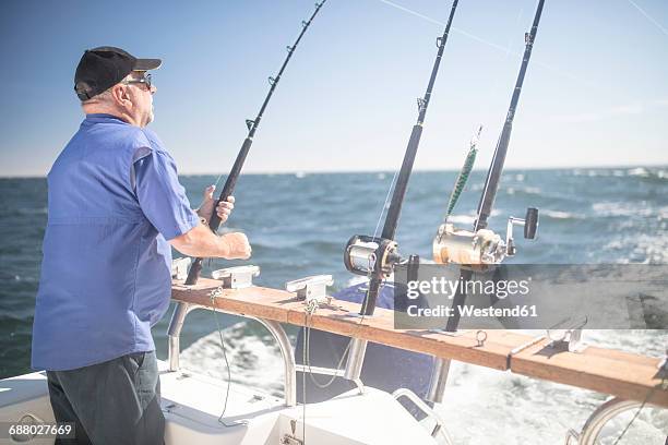 man on boat deep sea fishing - deep sea fishing stock-fotos und bilder