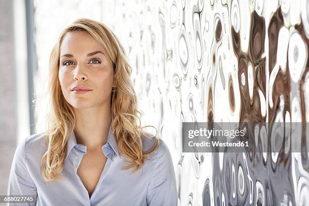 portrait of confident businesswoman at rippled wall - metallic blouse stock pictures, royalty-free photos & images