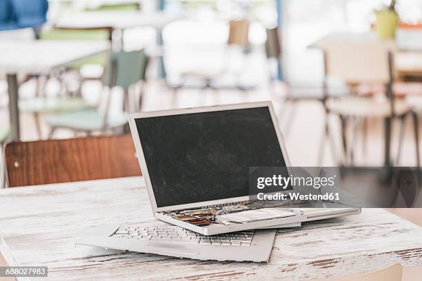 broken laptop on work desk - broken laptop stockfoto's en -beelden