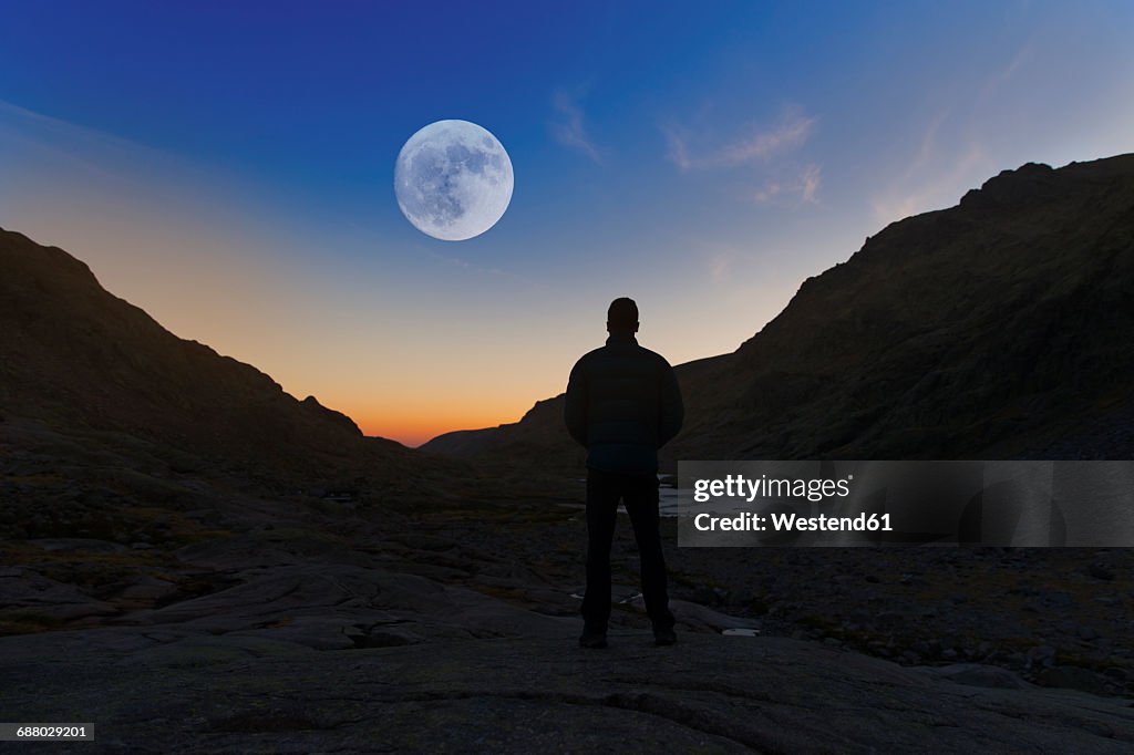 Spain, Sierra de Gredos, silhouette of man looking at the full moon