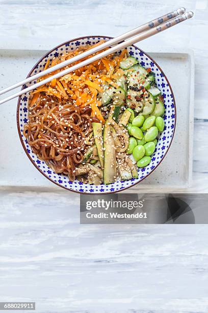 buddha bowl of edamame, cucumber, carrots, courgettes, shirataki noodles and sesame - buddha bowl stockfoto's en -beelden