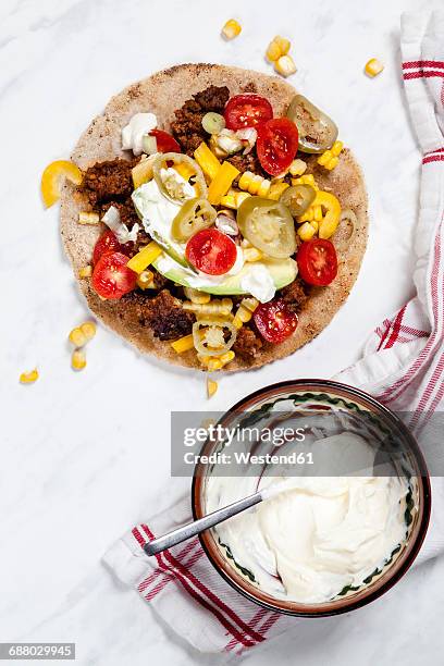 mexican tortilla with mincemeat, avocado, tomato, corn, jalapeno pepper and sour cream - sour cream stock pictures, royalty-free photos & images