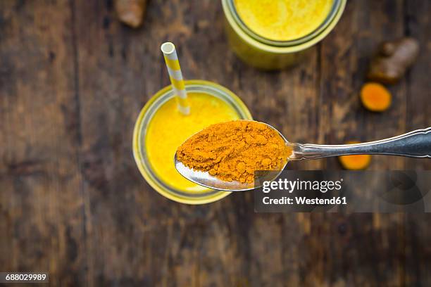 curcuma powder on tea spoon, close-up - theelepel stockfoto's en -beelden
