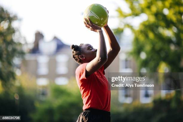 young woman practicing netball shooting in city - sports activity stock pictures, royalty-free photos & images