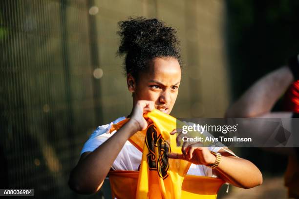 young netball player putting on her bib - startnummer stock-fotos und bilder