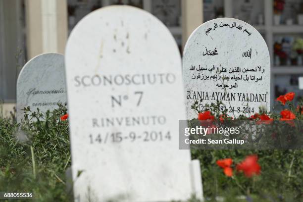 Tombstones stand at graves that, according to the cemetery caretaker, are the graves of migrants who died while trying to reach Italy on the island...