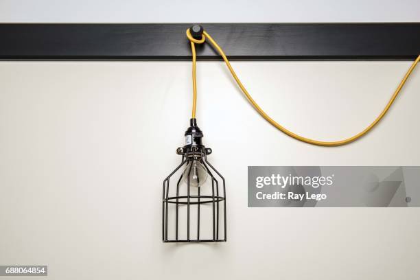 modern hanging lamp with yellow cord. - foco de luz fotografías e imágenes de stock