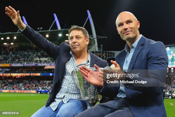 Cats Premiership heroes Mark Thompson the coach and captain Tom Harley get driven around the oval during the round ten AFL match between the Geelong...