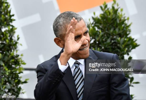 Former US president Barack Obama waves as he arrives on stage for a panel discussion with the German Chancellor during the Protestant church day...