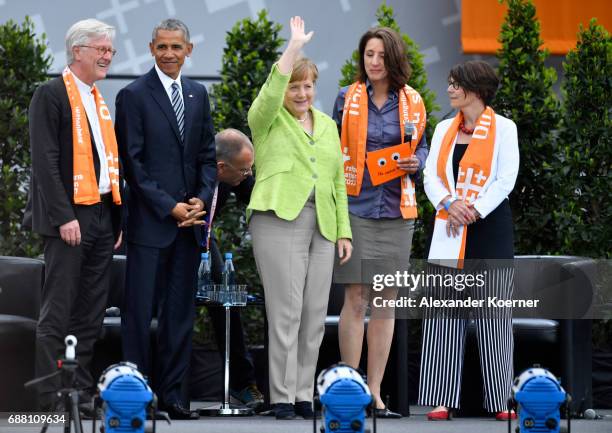 Former President of the United States of America, Barack Obama and German Chancellor Angela Merkel walk on stage at the Brandenburg Gate during the...