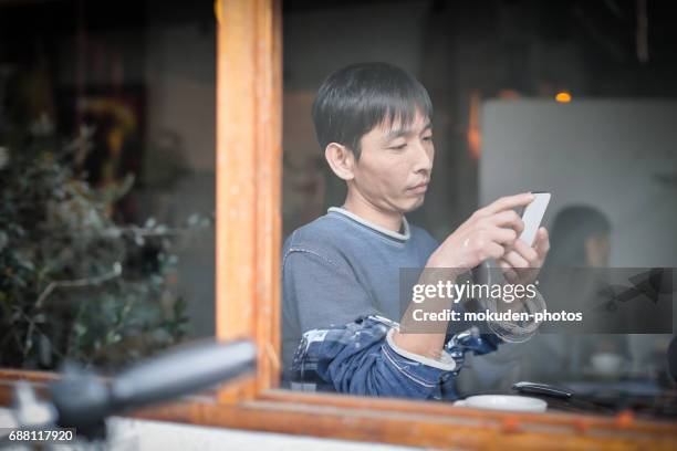 gelukkig japanse man ontspannen vakantie in het café - オーナー stockfoto's en -beelden