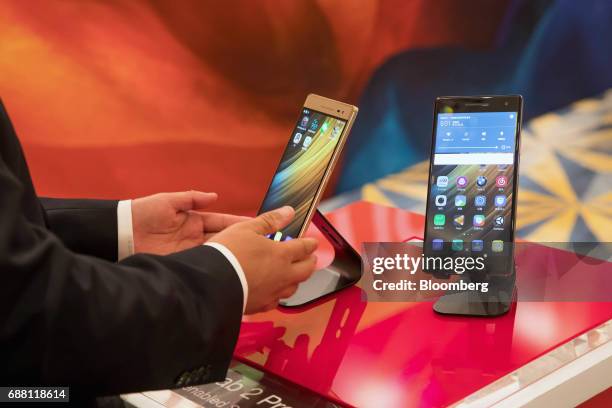 An attendee holds a Lenovo Group Ltd. Moto smartphone on display during a news conference in Hong Kong, China, on Thursday, May 25, 2017. Lenovo's...