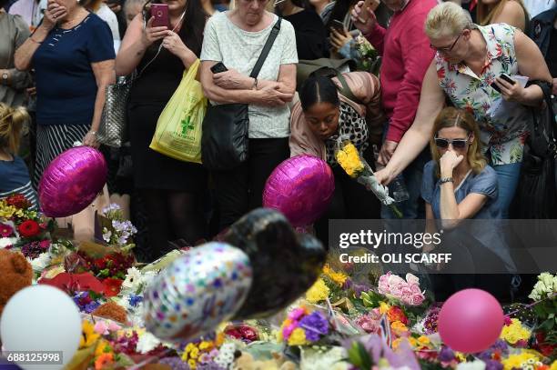 People stop to observe a minute's silence in St Ann's Square in Manchester, northwest England, on May 25 as a mark of respect to the victims of the...