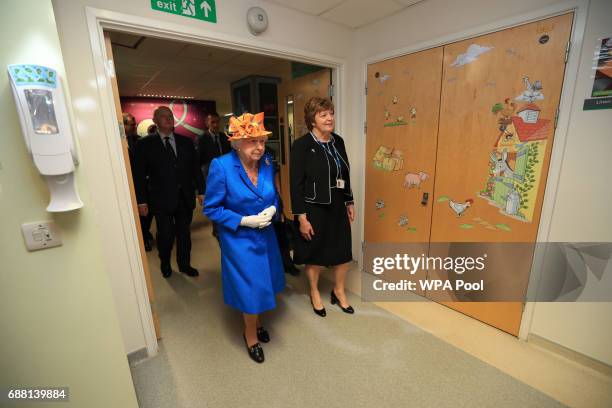 Queen Elizabeth II escorted by Kathy Cowell Chairman of the Central Manchester University Hospital, during a visit to the Royal Manchester Children's...