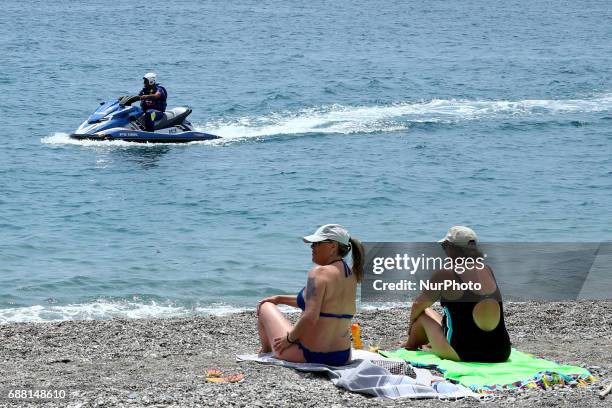 Two woman on the seaside looking to a jet sky patrolling the coast at Taormina, Italy on May 25, 2017. Leaders of the G7 group of nations, which...