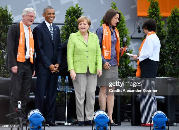 Former President of the United States of America, Barack Obama and German Chancellor Angela Merkel walk on stage at the Brandenburg Gate during the...